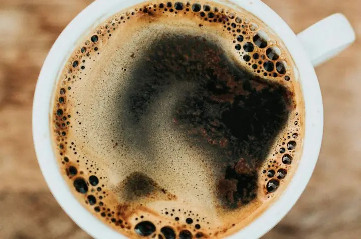 A cup of coffee with latte art on a saucer